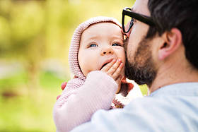 春天自然的父亲与他的蹒跚学步的女儿在外面