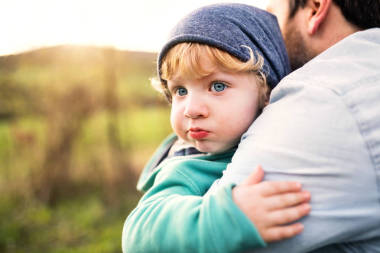 一個父親與他的蹣跚學(xué)步的兒子在春季自然外