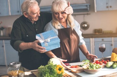 快樂成熟的男人給他的妻子禮物盒