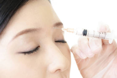 年輕女子在她的臉上注射美容