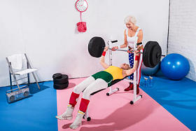 sporive 高级妇女在健身房锻炼杠铃