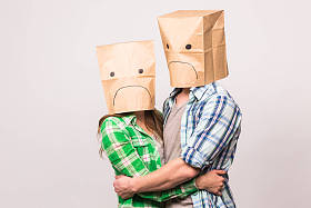 人, 关系困难, 冲突并且家庭概念-不愉快的夫妇用纸袋子覆盖他们的面孔在白色背景下