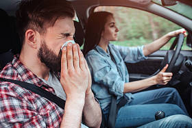生病的人正在开车。他在餐巾上打喷嚏。女孩在开汽车。她直视前方