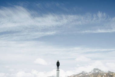 男人獨自站在柱子上看著天空和山脈的寂寞和簡約的概念, 復(fù)制空間 
