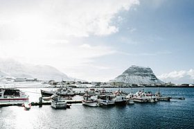 Kirkjufell 山和港口与小船在 Grundarfjordur 镇。冰岛 Snaefellsnes 半岛北岸, 冰岛