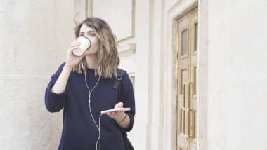 一個微笑的黑發(fā)白人女孩在外面聽音樂