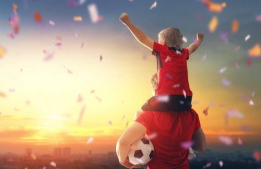 可愛的小孩子夢(mèng)想成為一名足球運(yùn)動(dòng)員。男孩與人在日落踢足球。家庭體育