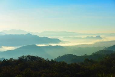 美丽的天空和金色的云彩。日出前的群山。清晨。太阳从山顶升起