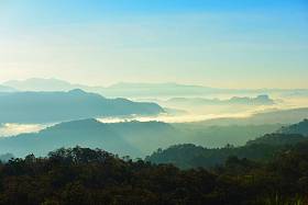 美丽的天空和金色的云彩。日出前的群山。清晨。太阳从山顶升起