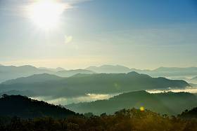 美丽的天空和金色的云彩。日出前的群山。清晨。太阳从山顶升起