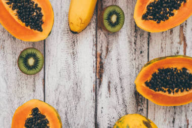 全芒果, 香蕉, 木瓜和猕猴桃在破旧的木质背景上的最高视图