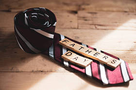 快乐的父亲日概念。红色领带和木块与父亲日文本在木桌背景上