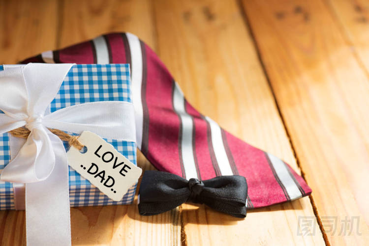 快樂的父親日概念。紅色領帶和禮物盒與愛爸爸標記在木桌背景