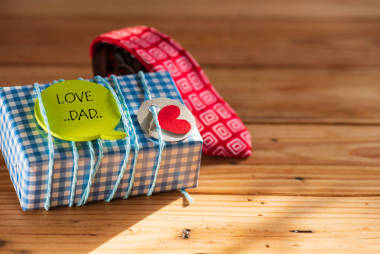 快乐的父亲日概念。红色领带和礼物盒与爱爸爸标记在木桌背景