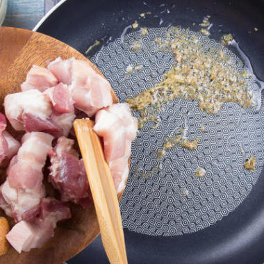 厨师把五花肉放在平底锅里/烹饪的概念甜棕色红烧猪肉汁(Moo Pa