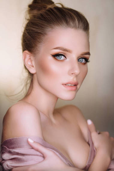 工作室肖像迷人的年輕金發(fā)女郎與藍(lán)色的眼睛擺在背景