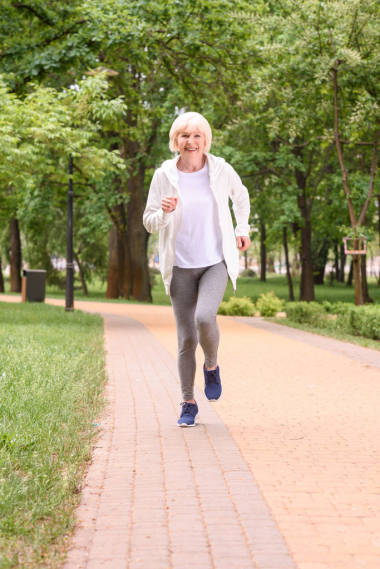 微笑高级运动员在公园里奔跑图片