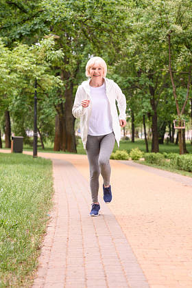 微笑高级运动员在公园里奔跑图片