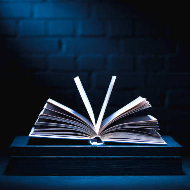 打開書在黑暗的表面與光在頁