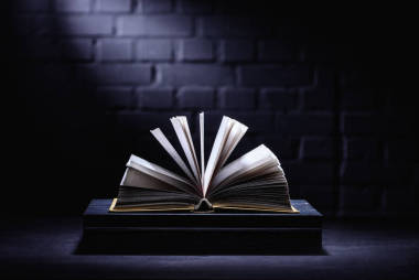 打開書在黑暗的桌面與光在頁
