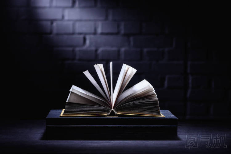 打開書在黑暗的桌面與光在頁(yè)