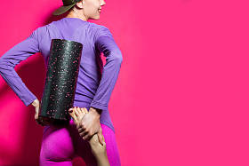 明亮的健身妇女。运动时尚。有趣的运动健身妇女与泡沫滚筒隔离过明亮的背景