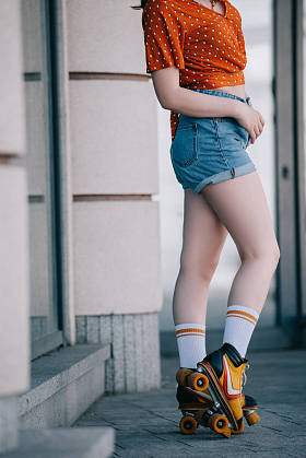 在街道上的轮滑鞋的时尚年轻女子裁剪镜头