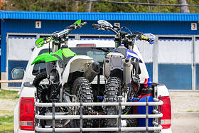 后方视图与二辆尘土自行车摩托车在卡车的后面与安全设备在住宅设置