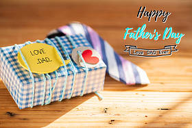 快乐的父亲日概念。彩色领带和礼物盒与爱爸爸标签在木桌背景