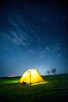 星光灿烂的天空下, 夜晚群山中闪耀的露营帐篷