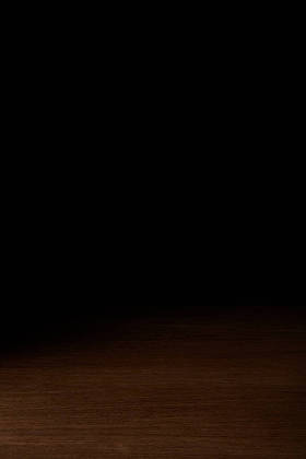 黑色背景下的乡土木桌特写视图