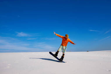陽光明媚的日子, 沙漠中的沙子登入。在沙丘上滑雪時(shí), 人們會捉弄藍(lán)天。廣角