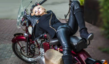 穿黑色高靴金發(fā)的女人, 舊的皮革夾克, 老式的, 復(fù)古的摩托車 