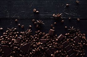 木桌上的八角、巧克力片和咖啡豆堆的高视图