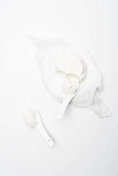 在白色表面用勺子制作的自制平房干酪的頂級(jí)視圖