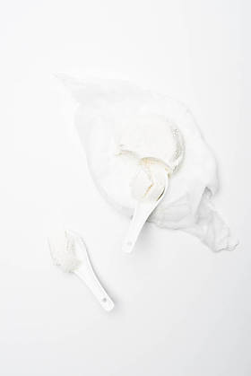 在白色表面用勺子制作的自制平房干酪的顶级视图