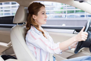 有吸引力的婦女的側(cè)面看法駕駛汽車單獨(dú)