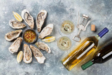 石桌上的新鮮牡蠣和白葡萄酒。頂部視圖