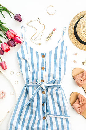 夏季女性时尚的构图。礼服, 拖鞋, 稻草, 郁金香花和配件在白色的背景。平躺, 顶部视图