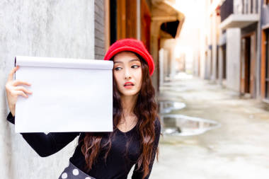 迷人的美女正在看空紙或復(fù)印空間。華麗的女人在城里拿著圖畫(huà)書(shū)。迷人的美麗女人的行為像一個(gè)驚人的, 欣賞, 喜歡或愛(ài)廣告