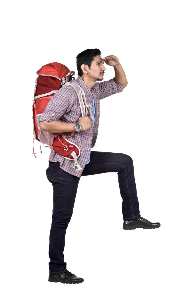 站在白色背景上的亚洲旅行者看风景的侧面视图 站在白色背景上的亚洲旅行者看风景的侧面视图