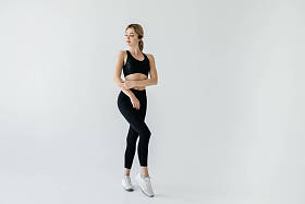 黑色运动服的年轻金发运动员在灰色的伪装