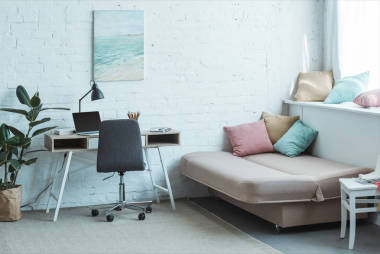 沙發(fā)帶枕頭和桌子的筆記本電腦在客廳