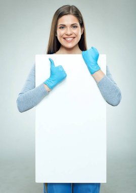 微笑的婦女在手套舉行廣告空的橫幅和顯示拇指向上