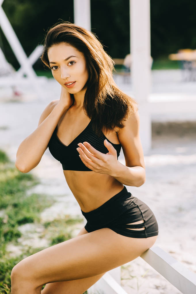 美丽的女孩在阳光明媚的夏日锻炼后休息