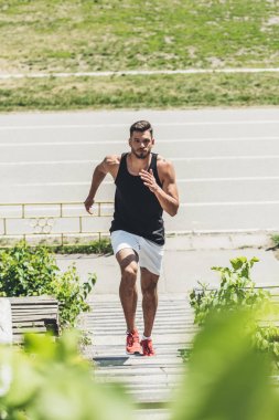 体育游乐场台阶上青年运动员的高视角