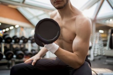 運動中心訓(xùn)練中的肌肉少年一只手重杠鈴運動