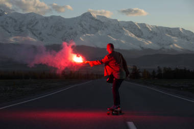 少女在山上的道路上的假滑板紅色火