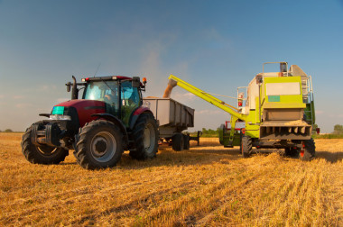 现代联合收割机收割机卸粮到拖拉机上阳光灿烂的夏天一天