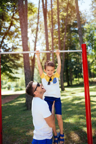 父亲训练他的儿子在水平的酒吧